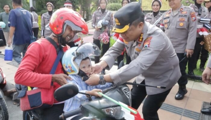 HUT RI ke-80, Polrestabes Surabaya Bagikan Bendera dan Helm untuk Pengendara